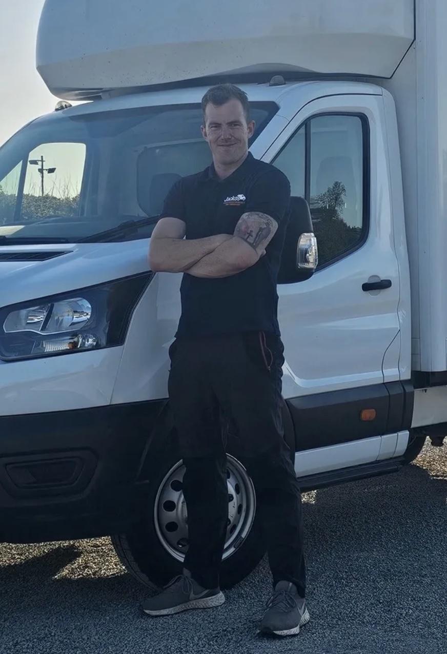 Billy Jackson, founder of Not Just Any Van, standing with his arms folded in front of a white Luton removals van